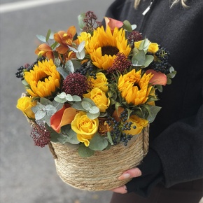 Композиция в сумке "Тональность" из подсолнухов, калл, ягод вибирнума, лимонных роз, скиммии и орхидеи в Королеве